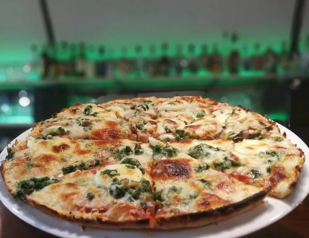 Detail naší originální pizzy s uzeným masem a špenátem.